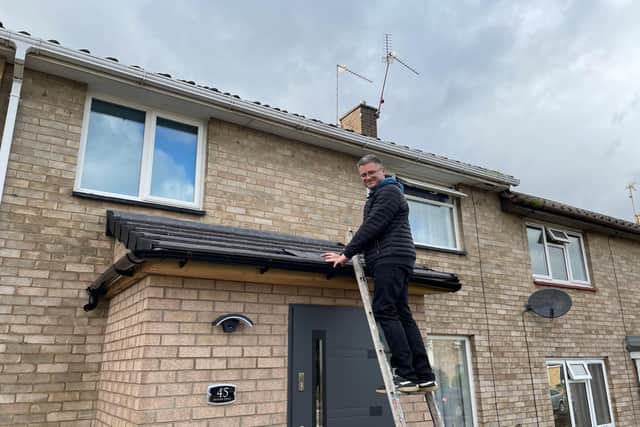 Tomasz Brezezniski fixes his roof in Newark Drive