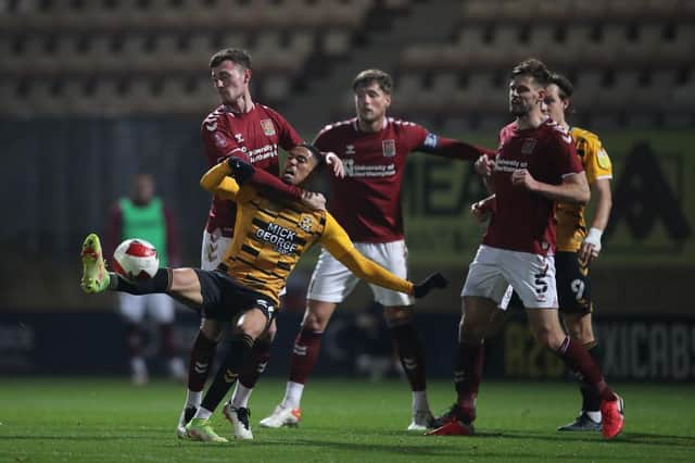 Cambridge United striker Harvey Knibbs gets caught in a tangle with Cobblers defender Paul Lewis (Picture: Pete Norton)