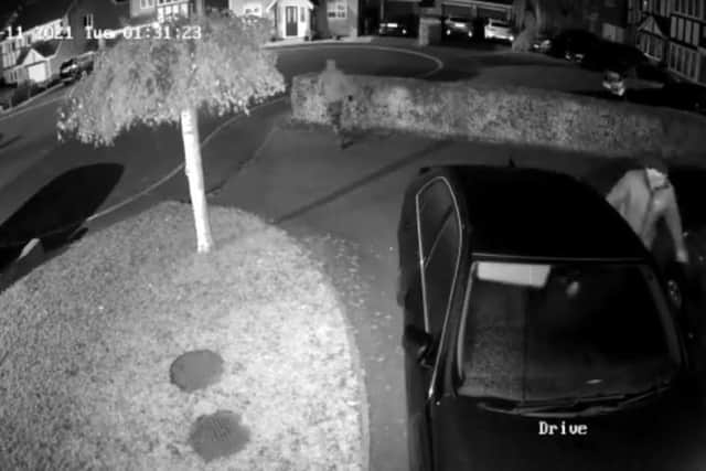 A screenshot of Councillor Chowdhury's home CCTV shows one man in a balaclave testing his car door and another hooded man walking off