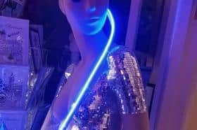 The neon disco diva is currently in the entrance of the shop