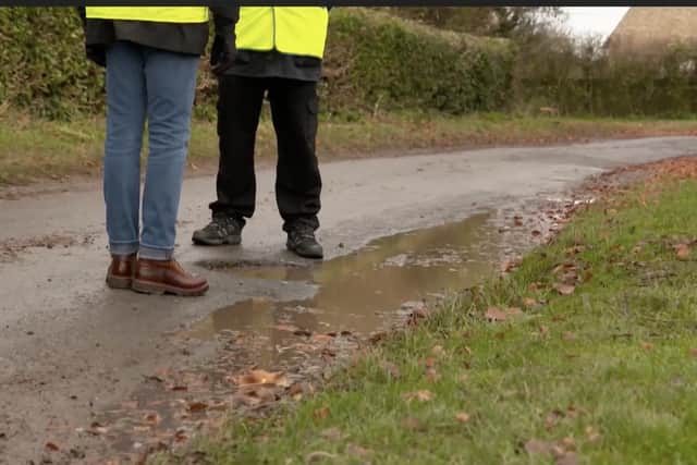 The pothole is disguised by water from the nearby field, making it an even worse danger to cars, cyclists and horse riders