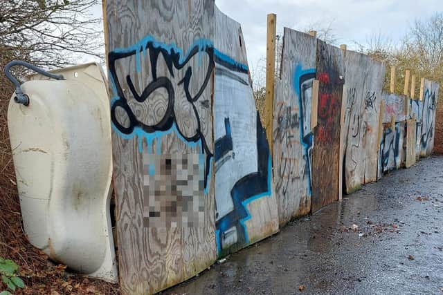 The Nazi swastika can be seen graffitied on the fly-tipping barricade
