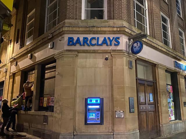 Protesters put up posters at Barclays in the Drapery