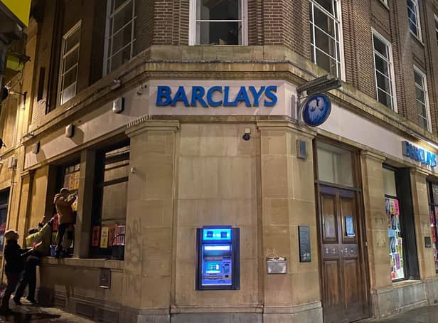 Protesters put up posters at Barclays in the Drapery