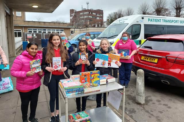 Wootton Primary School's house captains handing over children's books to the Disney Ward at Northampton General Hospital.
