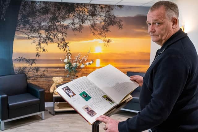 Managing director at PCS, Glenn Tuck, holding a remembrance book.