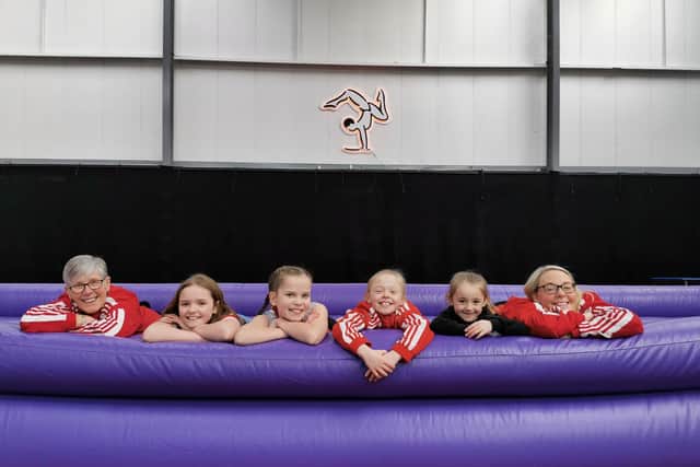 Gym owners Jayne and Jessica (far left and far right) on the new piece of equipment they bought with the money.