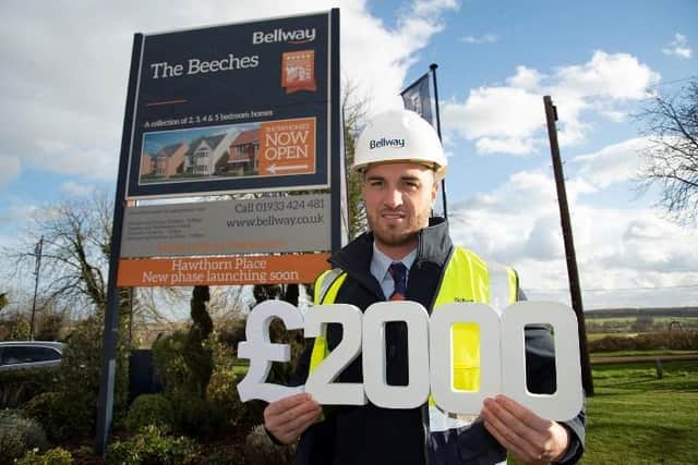 Ross Jenkins, Bellway Northern Home Counties site manager proudly holding the £2000 figure he raised for The Adobe Project