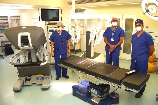 Left to right: Consultant Urological Surgeons Mr Hemant Nemade and Prasanna Sooriakumaran with Consultant Anaesthetist Sada Chinniah and the new robot at Northampton General Hospital.
