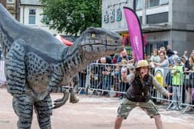 A life-sized dinosaur entertaining crowds in Market Square last year. Photo: Kirsty Edmonds.