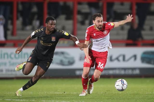 Cobblers attacker Beryly Lubala tussles with Stevenage's Ed Upson during Town's 2-1 win on Tuesday night (Picture: Pete Norton)