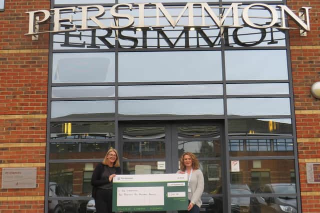 From left, Wendy Cooper from Persimmon Homes Midlands hands over £2,200 to Ellie White from The Lowdown
