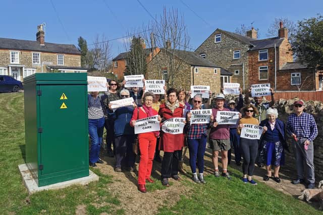 Deanshanger residents stood outside the green box on Tuesday morning (March 22) holding signs reading: 'Save our green spaces'.