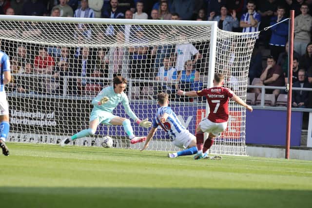 Sam Hoskins slips through the legs of Hartlepool goalkeeper Nicholas Bilokapic to give Cobblers the lead in Saturday's League Two game. Picture: Pete Norton.