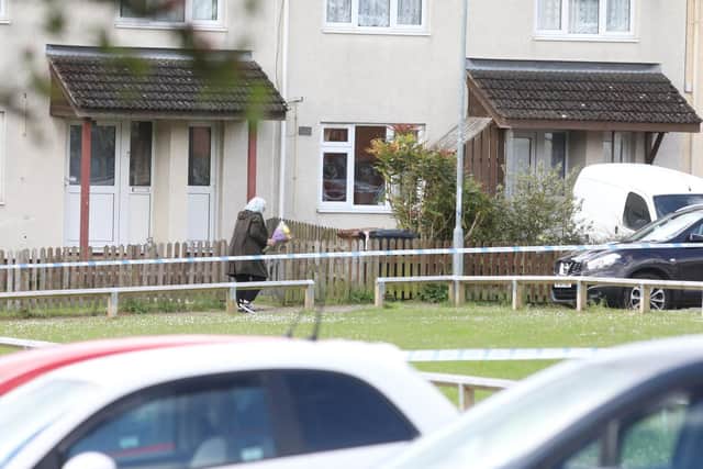 A neighbour leaves flowers at the scene.