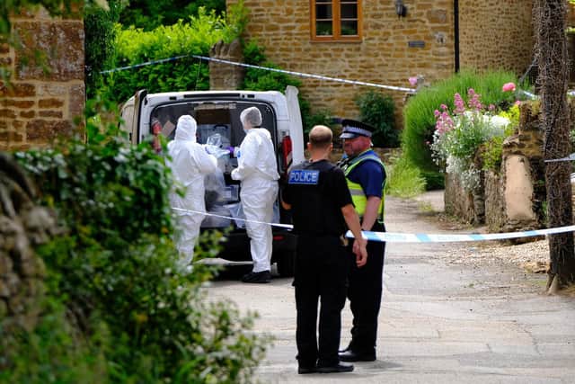 Forensic investigators gather evidence after a man's body was found in a blazing shed