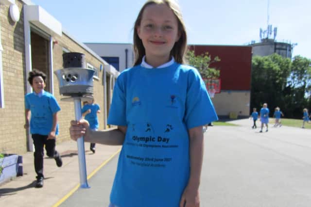 Hardingstone Academy pupils taking part in East Midlands Academy Trust's Walk to Tokyo challenge, with their own Olympic torch