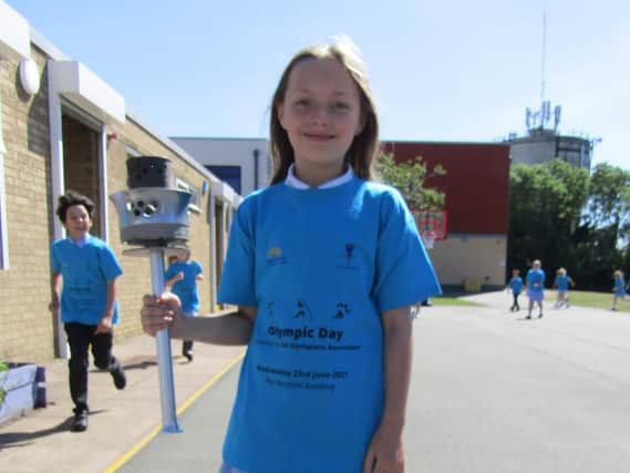 Hardingstone Academy pupils taking part in East Midlands Academy Trust's Walk to Tokyo challenge, with their own Olympic torch