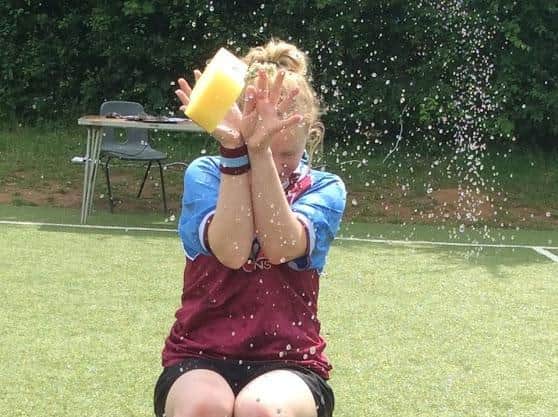 Boughton Primary School reception teacher Nicola Cook gets hit with a wet sponge during the 'soak a teacher' contest