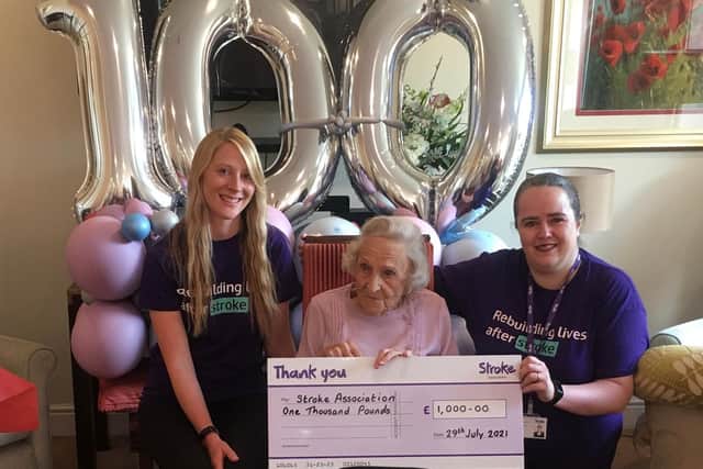 Betty Sheppard presenting the donations to representatives from the charity.