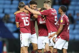 Kion Etete is mobbed by his team-mates after giving Cobblers the lead against Coventry.