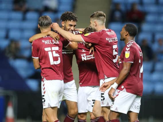 Kion Etete is mobbed by his team-mates after giving Cobblers the lead against Coventry.
