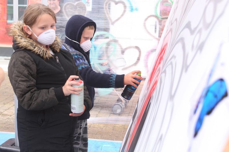 Amy Hannett age eight, and brother Dan Junior, age six, spray painting the giant mural for Littlehampton town. Photo by Derek Martin Photography