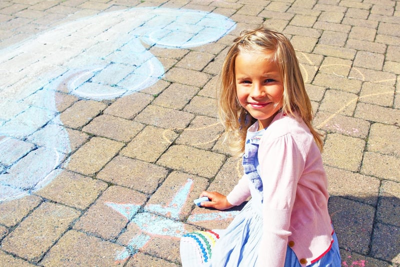 Hattie Wood, age seven, enjoying her time in the sun whilst getting creative with the chalks. Photo by Derek Martin Photography