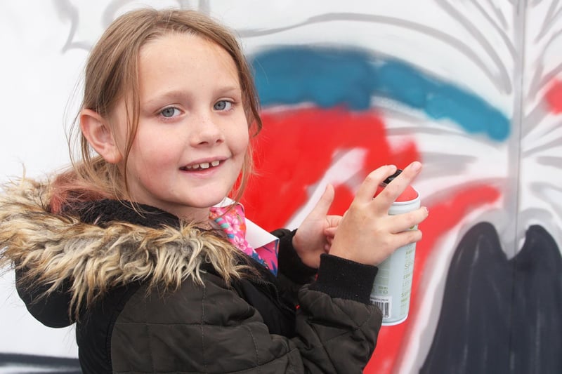 Amy Hannett, age eight, spray paining the six foot mural for Littlehampton town.  Photo by Derek Martin Photography