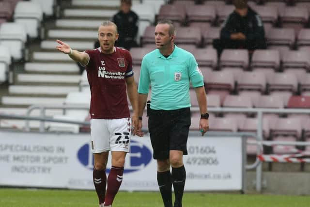 Cobblers skipper Joseph Mills has a word with referee Carl Brook.
