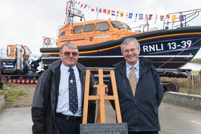 Pwllheli RNLI chair Alan Jones and Charles Denton, godson of Richard Colton unveil a plaque at the new boathouse