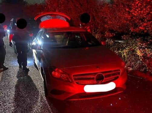 Armed officers search the Mercedes after chasing it down on the M1