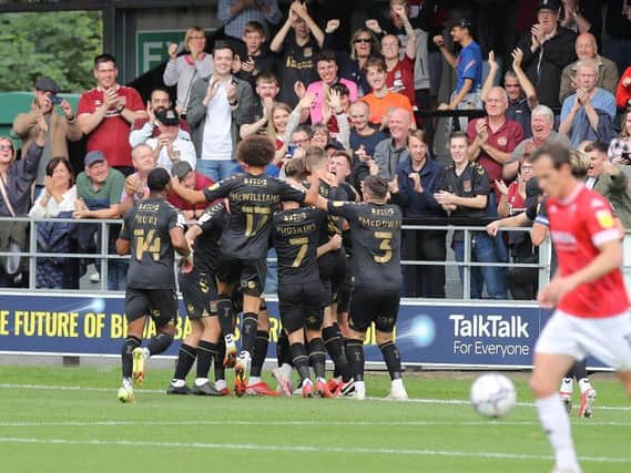 Cobblers players and fans celebrate Paul Lewis' opening goal. Pictures: Pete Norton.