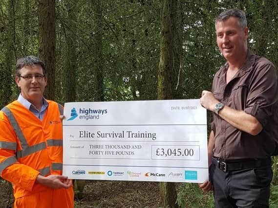 National Highways' Dermot Doherty hands over the cheque to John Sullivan of Elite Survival Training