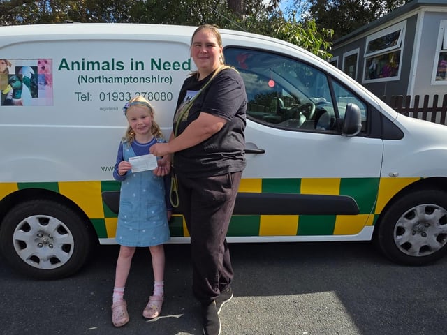 Ava handing over £251 cheque to Emma at Animals in Need.