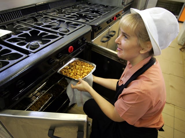 Hot dinners returning to schools. Cygnet Catering working from Goldings Middle school Kitchen. Food is loaded from oven, checked with a probe (for temp) and then loaded into special hot boxes.