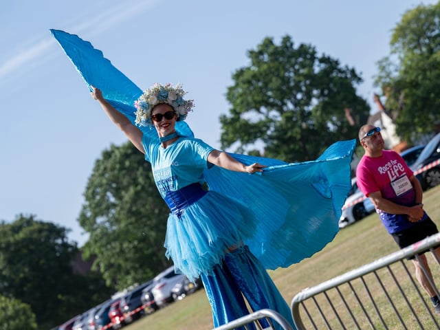 A performer on stilts helping to warm up race goers taking part in the Race For Life at Abington Park in Northampton on Sunday, July, 12, 20026. Photo by David Jackson.