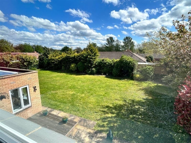 Upstairs windows look out onto a lush garden below