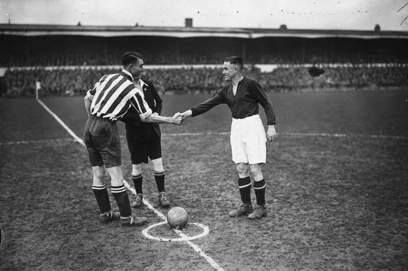 Southampton captain, Bradford, shakes hands with Northampton captain, Crilly, before the kick off of an FA Cup tie replay between Northampton Town and Southampton at Northampton in 1934.