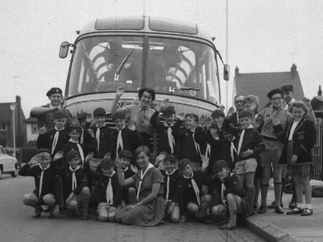 Cubs in front of bus going on a trip