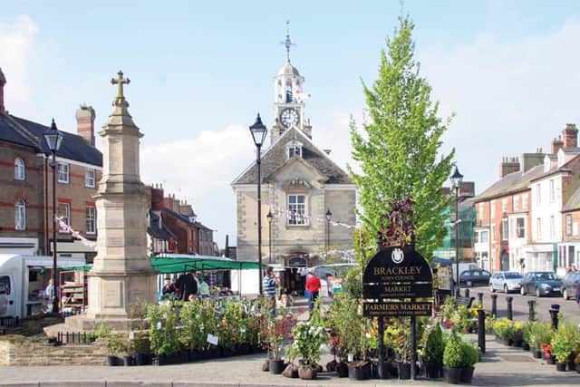 Brackley Town Centre with greenery around a church in the background