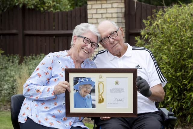Margaret, 81, and Stephen Parker, 84, holding their framed card from the Queen for their Diamond wedding anniversary. Photo by Kirsty Edmonds.