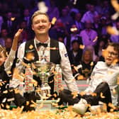 Kyren poses with his children on the table alongside confetti to celebrate his World Championship win.