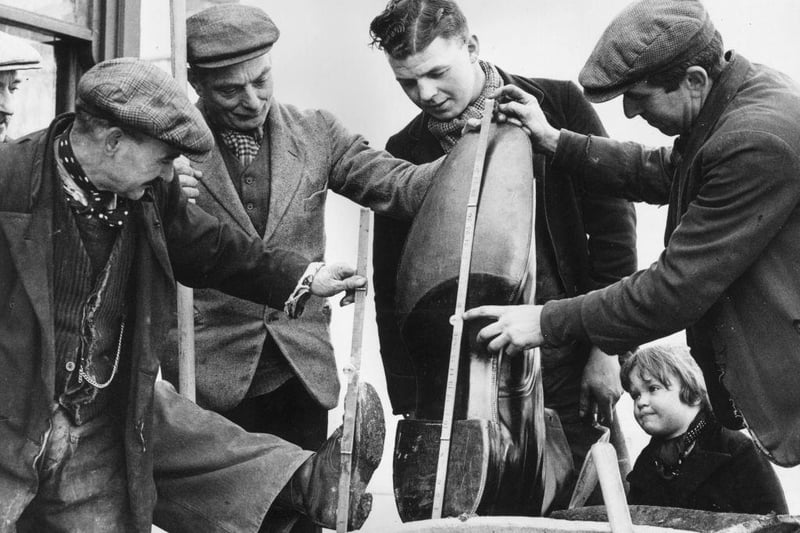 Roadmen inspect a giant boot made especially made for Northampton Town Football Club on 12th March 1937.