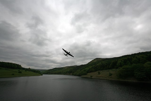 A Lancaster bomber flies over Ladybower reservoir in the Derbyshire Peak District to mark the 65th anniversary of the World War II Dambusters mission in Derwent, England. Ladybower and Derwent reservoirs were used by the RAF's 617 Squadron in 1943 to test Sir Barnes Wallis'  bouncing bomb before their mission to destroy dams in Germany's Ruhr Valley.  (Photo by Christopher Furlong/Getty Images)