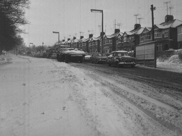 A lorry struggles uphill in snow, date unknown