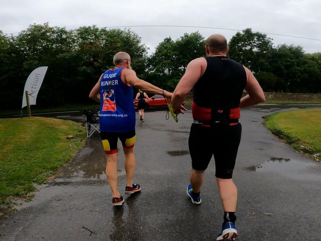 Andy guiding Steve at a busy road during the 5K run of the triathlon.