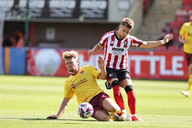 Cameron McGeehan goes sliding into a challenge against Cheltenham