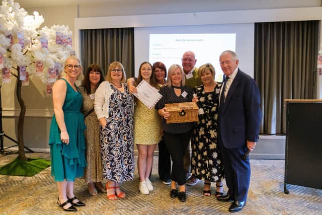 Andrea Smith from Franklins Solicitors (L) and Nick Hewer (R) pose with John Lewis winning team