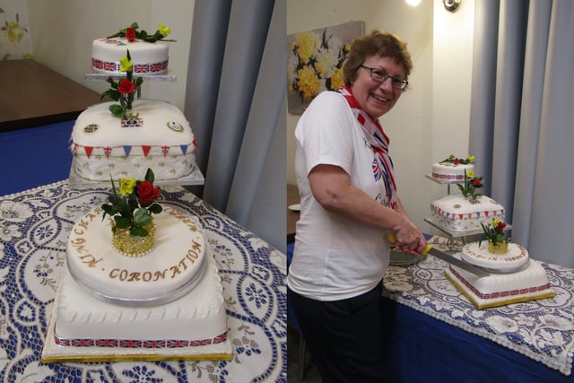 Reverend Rachel Hetherington makes the first cut to the delicious Coronation cake, which was made and decorated by independent living resident, Grace.